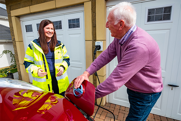 Image of SSEN employee speaking to customer who is charging their electric vehicle 